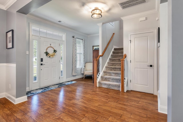 entryway with hardwood / wood-style floors and crown molding