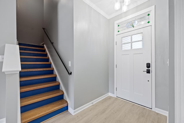 foyer entrance with ornamental molding and light wood-type flooring