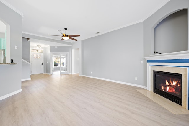 unfurnished living room featuring a premium fireplace, crown molding, and light hardwood / wood-style floors