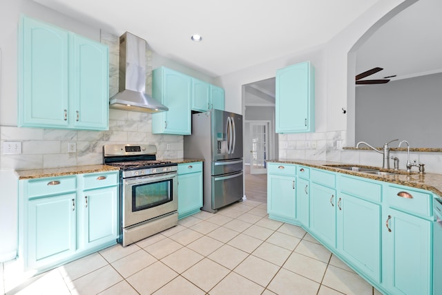 kitchen with wall chimney exhaust hood, sink, tasteful backsplash, and stainless steel appliances