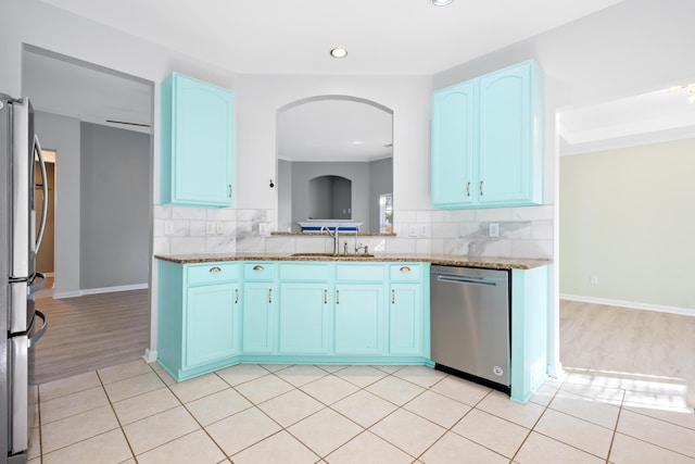 kitchen with sink, blue cabinetry, appliances with stainless steel finishes, and decorative backsplash