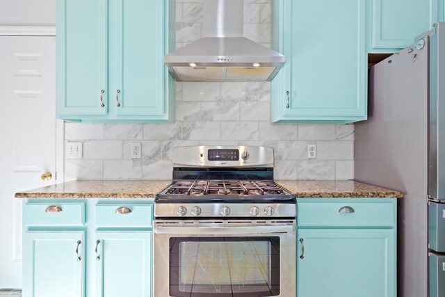 kitchen with stainless steel appliances, decorative backsplash, light stone countertops, and extractor fan