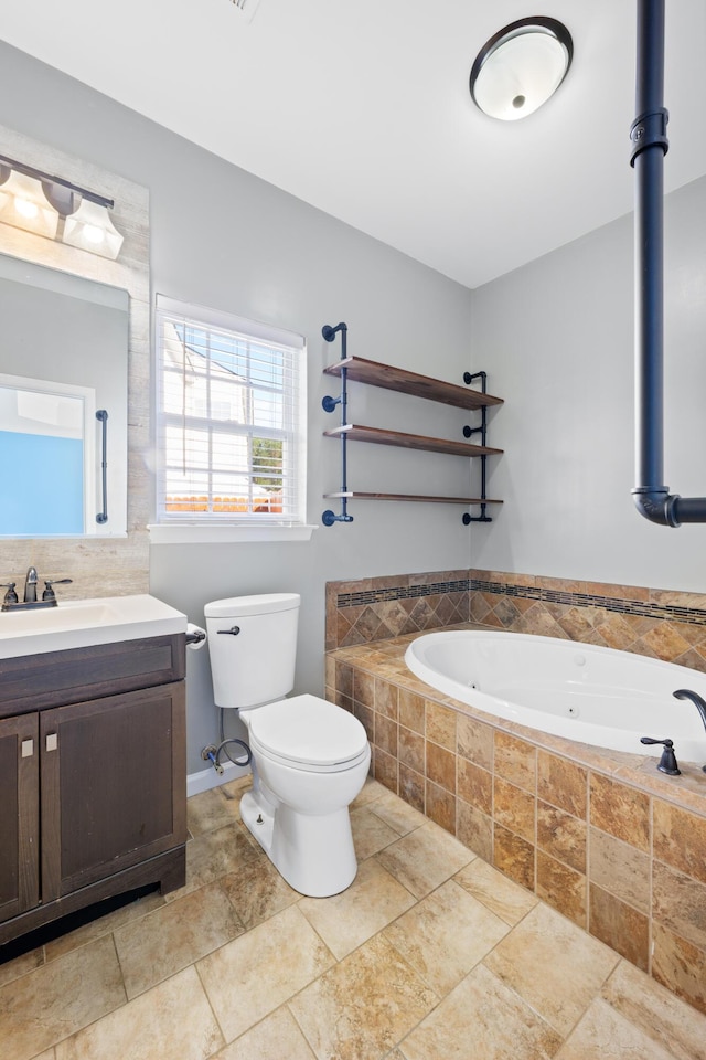 bathroom with tiled tub, toilet, and vanity