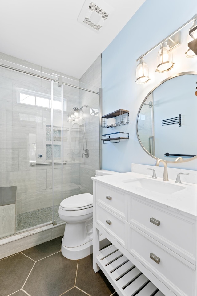 bathroom featuring vanity, toilet, a shower with shower door, and tile patterned flooring