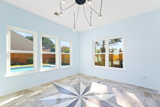 unfurnished sunroom with a notable chandelier