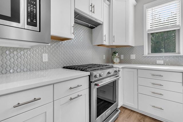 kitchen featuring light hardwood / wood-style floors, white cabinetry, stainless steel stove, and tasteful backsplash