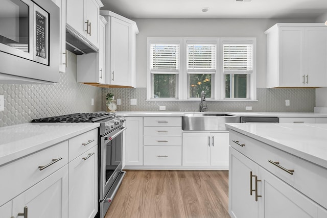 kitchen with white cabinets, appliances with stainless steel finishes, and sink