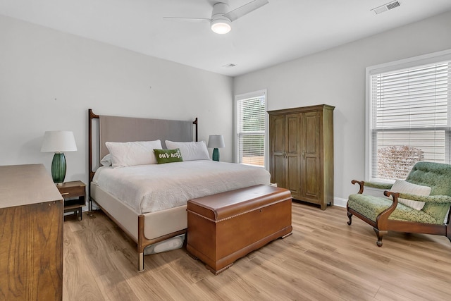 bedroom with ceiling fan, light wood-type flooring, and multiple windows