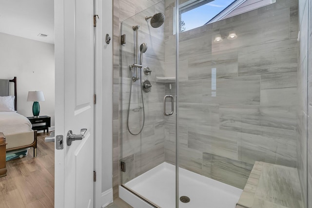 bathroom featuring wood-type flooring and an enclosed shower