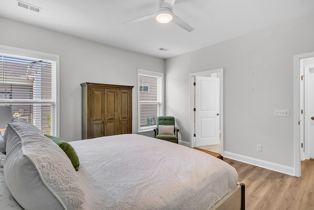 bedroom featuring multiple windows, ceiling fan, and light wood-type flooring