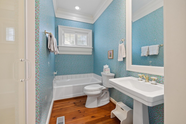 bathroom featuring a tub, crown molding, toilet, and hardwood / wood-style floors