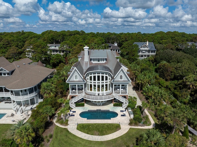 rear view of property featuring a patio and a balcony