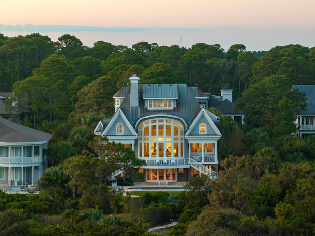 back house at dusk featuring a balcony