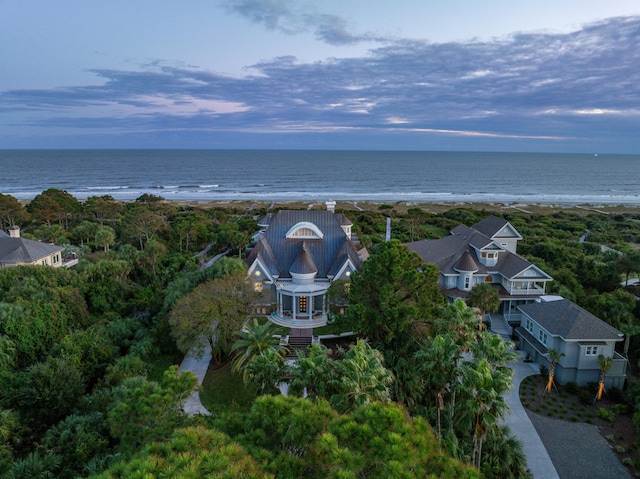 aerial view at dusk with a water view and a beach view