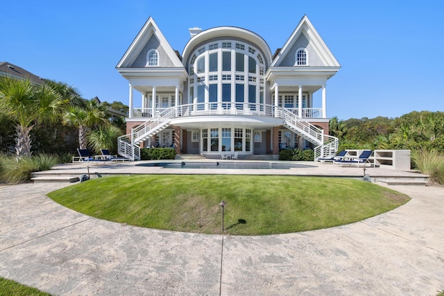 rear view of house with a yard, covered porch, and french doors