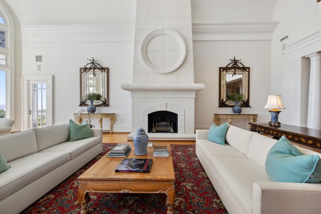 living room featuring crown molding, wood-type flooring, and a fireplace