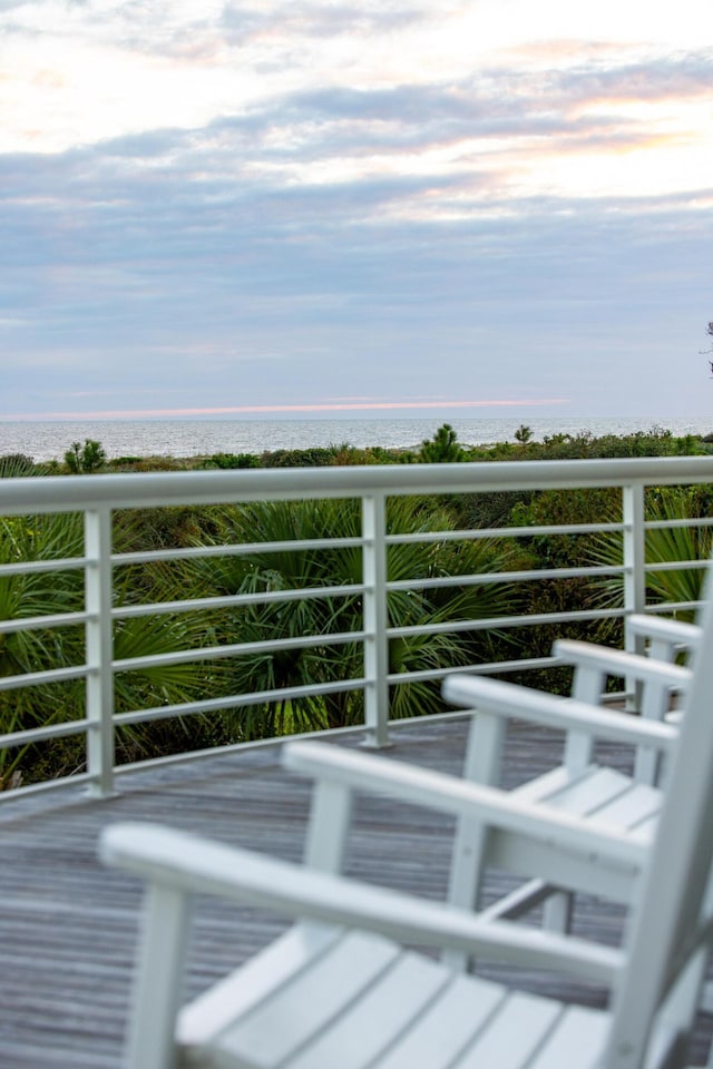 balcony featuring a water view and a beach view