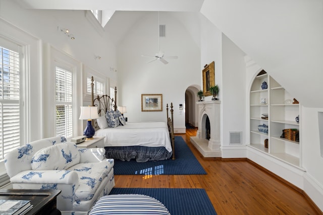 bedroom with high vaulted ceiling and hardwood / wood-style floors