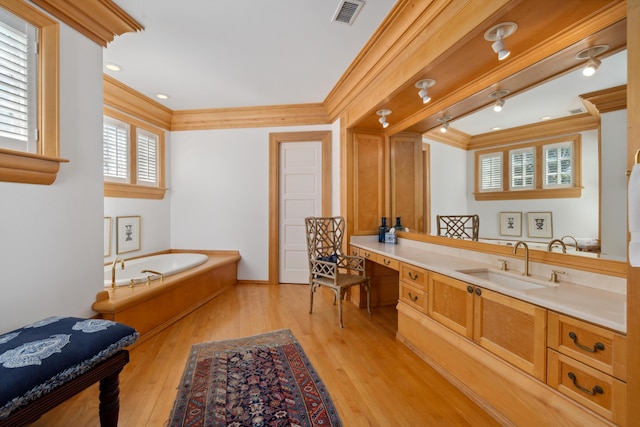 bathroom with vanity, hardwood / wood-style floors, crown molding, and a bath