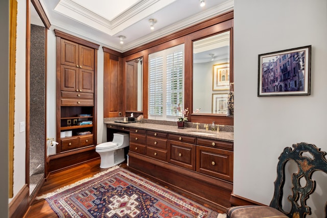 bathroom with vanity, toilet, hardwood / wood-style flooring, and crown molding