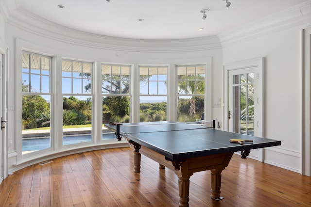 recreation room with hardwood / wood-style floors and crown molding