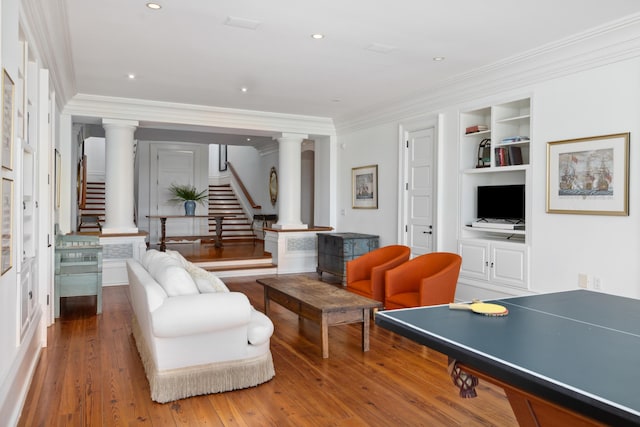 living room featuring crown molding, hardwood / wood-style floors, and built in shelves