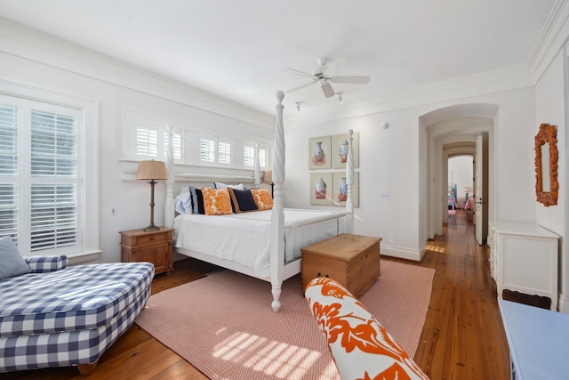 bedroom with dark wood-type flooring, crown molding, and ceiling fan