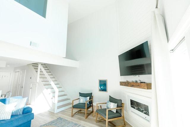 living room featuring light hardwood / wood-style floors and a high ceiling