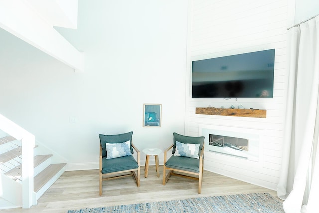 sitting room featuring a large fireplace and light hardwood / wood-style flooring