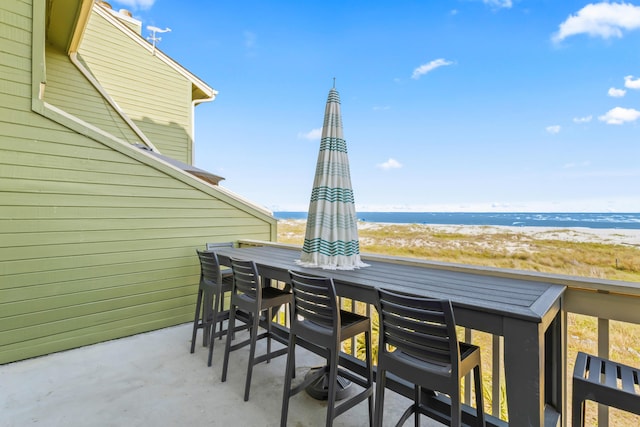 view of patio with a water view and a view of the beach