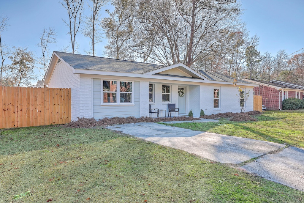 ranch-style house with a front yard and a porch