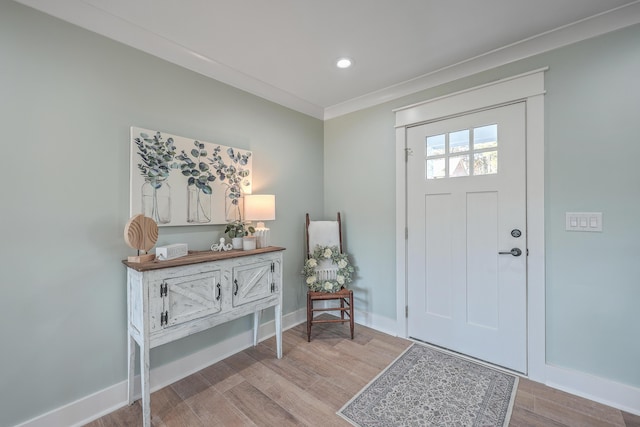 entryway with light hardwood / wood-style flooring and ornamental molding