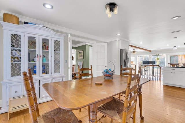 dining room featuring light hardwood / wood-style floors and crown molding