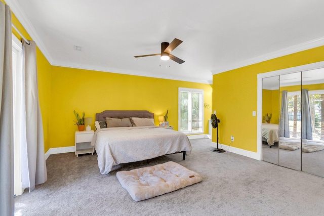 carpeted bedroom featuring multiple windows, ornamental molding, a closet, and ceiling fan