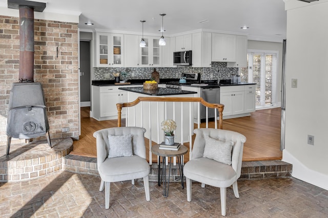 428 Carn St, Walterboro, SC 29488 - kitchen with a wood stove, glass insert cabinets, baseboards, dark countertops, and appliances with stainless steel finishes