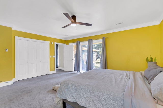 carpeted bedroom featuring crown molding, a closet, and ceiling fan