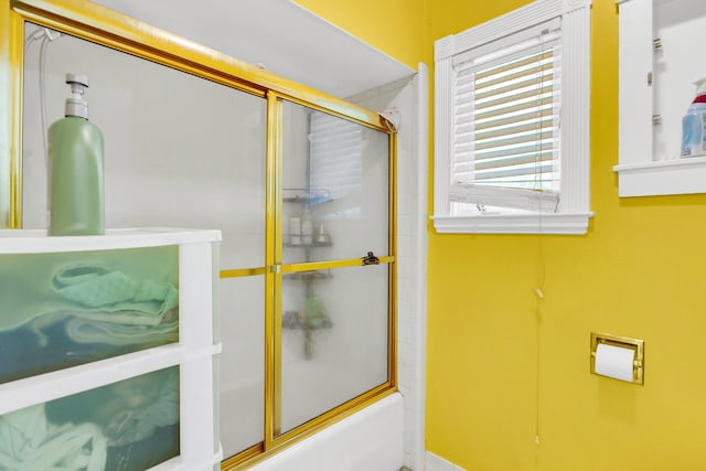 bathroom featuring bath / shower combo with glass door