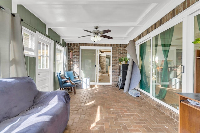 sunroom / solarium featuring beam ceiling and ceiling fan