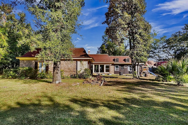 428 Carn St, Walterboro, SC 29488 - back of house with a lawn, a chimney, brick siding, and a playground