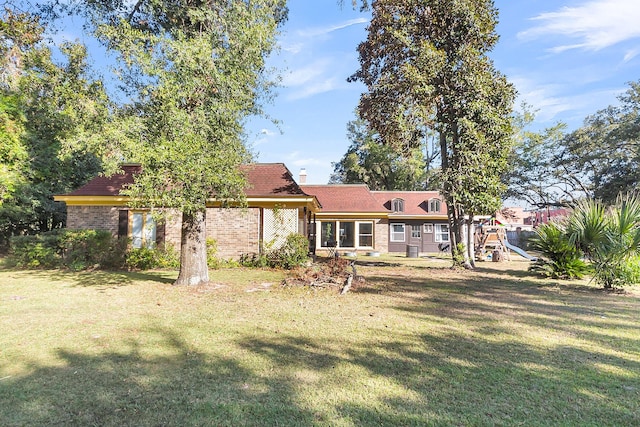 exterior space with a playground and a lawn