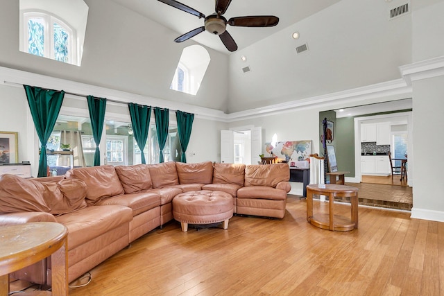 living room with light hardwood / wood-style floors, high vaulted ceiling, and ceiling fan