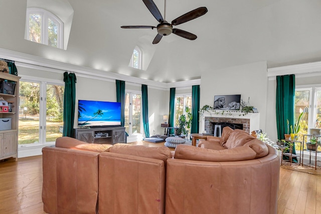 living room featuring ceiling fan, hardwood / wood-style flooring, plenty of natural light, and a fireplace