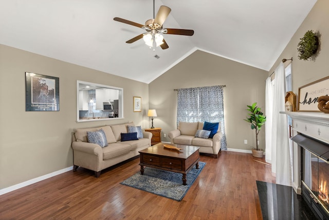 living room with vaulted ceiling, dark hardwood / wood-style floors, and ceiling fan