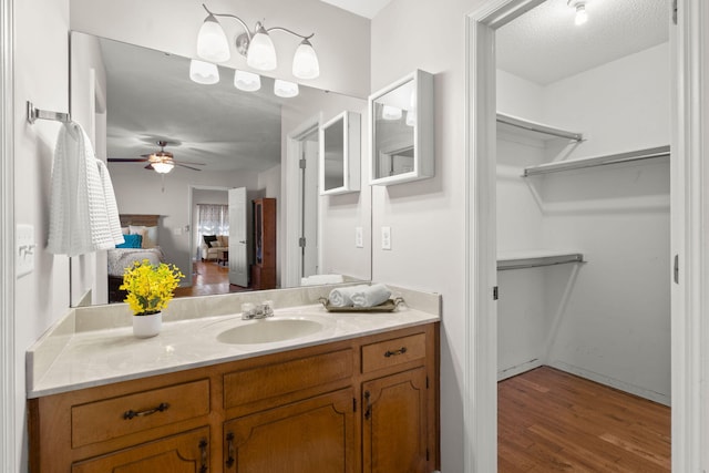 bathroom featuring hardwood / wood-style flooring, vanity, a textured ceiling, and ceiling fan