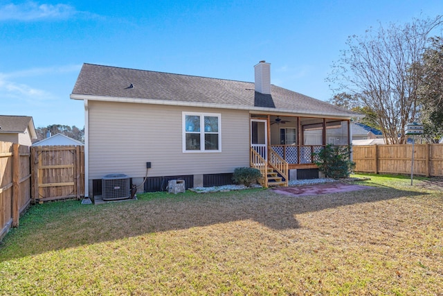 rear view of property with ceiling fan, central air condition unit, and a lawn