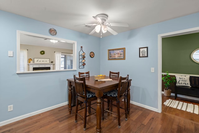 dining area featuring dark wood-type flooring and ceiling fan