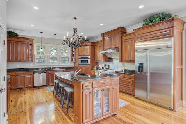 750 Navigators Run, Mount Pleasant, SC 29464 - kitchen featuring stainless steel appliances, brown cabinetry, open shelves, light wood-style floors, and a kitchen island with sink