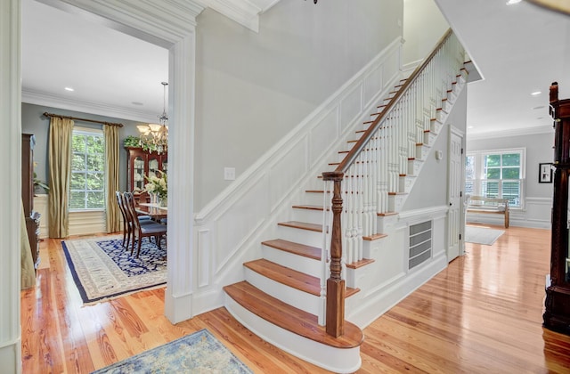 750 Navigators Run, Mount Pleasant, SC 29464 - staircase featuring ornamental molding, a decorative wall, wood finished floors, a chandelier, and a wainscoted wall