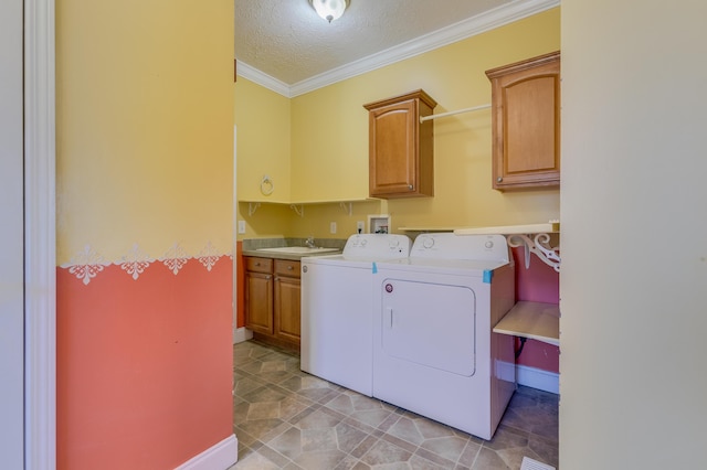 clothes washing area featuring washing machine and clothes dryer, crown molding, cabinet space, a textured ceiling, and a sink