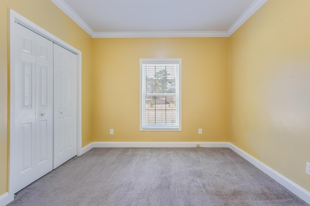 unfurnished bedroom featuring a closet, baseboards, carpet flooring, and crown molding